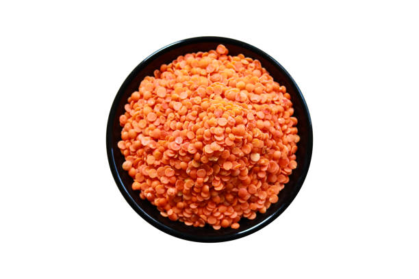 istock Red lentils in a black bowl isolated on white background. Top view. 2204293938