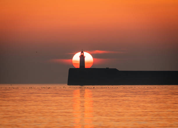 istock Newhaven lighthouse March sunset from Seaford Beach 2204295750