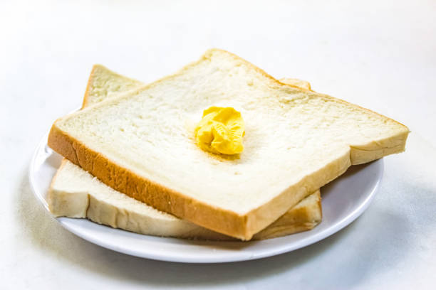 white bread with butter in a plate isolated on white background