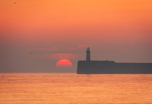 istock Newhaven lighthouse March sunset from Seaford Beach 2204296044