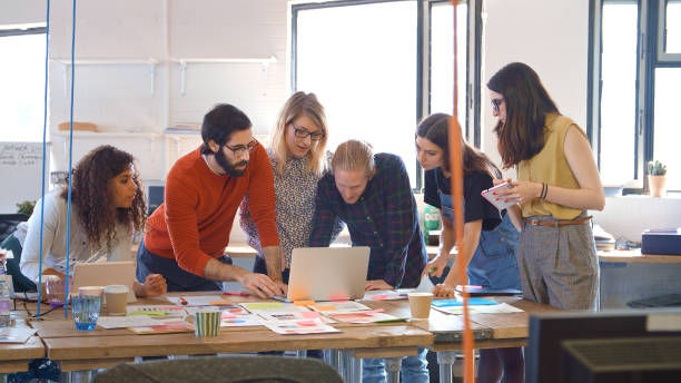 istock Multi-Cultural Business Team Meeting In Office Looking At Laptop And Documents 2204296413