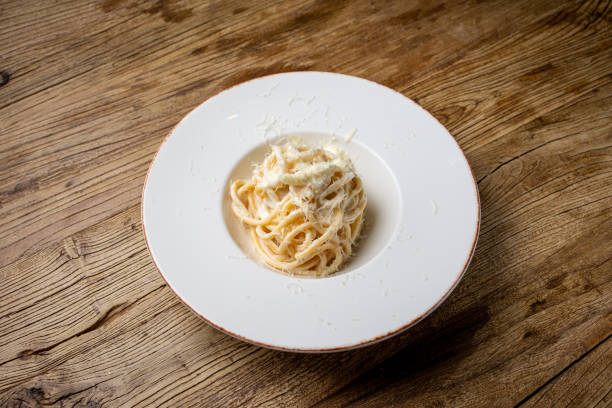 istock Spaghetti carbonara with parmesan cheese on a white plate 2204297145