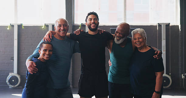 istock Mature people, personal trainer and friends in gym for exercise, workout or training. Physical therapy, support and help with portrait for fitness class, instructor and wellness for retirement health 2204301392