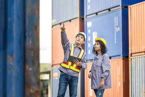 istock Workers collaborating at shipping container yard, Supervisor in safety gear and engineer man in hardhat checking containers box from container cargo 2204304760