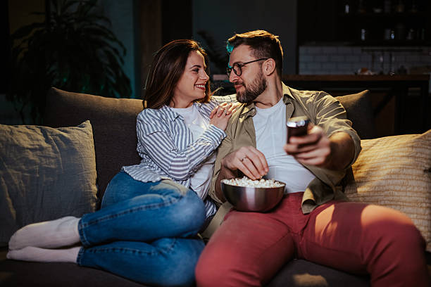 istock Couple enjoying movie night with popcorn 2204305369