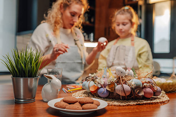 istock Mother and daughter painting easter eggs in the kitchen 2204305977