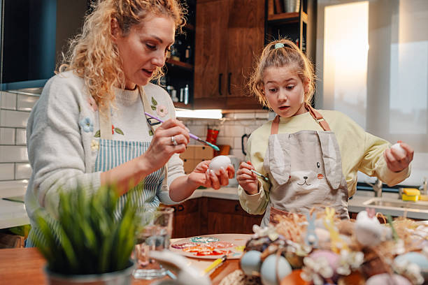 istock Mother and daughter painting easter eggs in the kitchen 2204305980