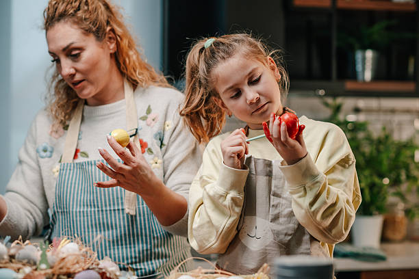 istock Mother and daughter painting easter eggs in the kitchen 2204306510