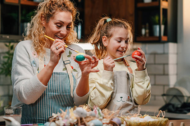 istock Mother and daughter painting easter eggs at home 2204306529