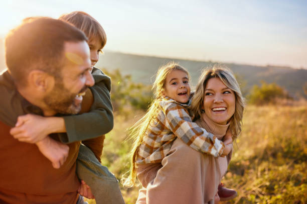 istock Happy family having fun while piggybacking in autumn day. 2204308643