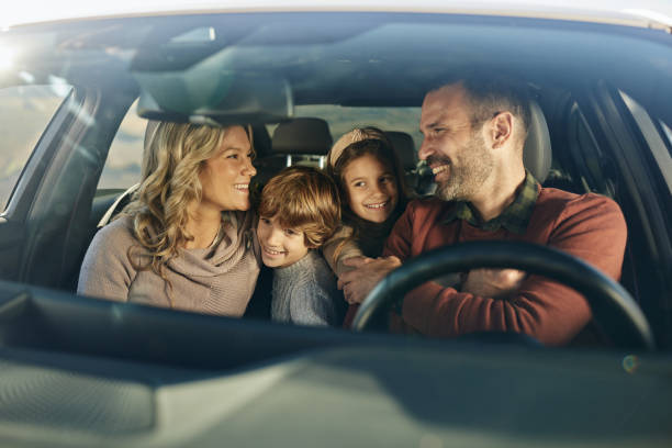 istock Happy family talking while going on a road trip by car. 2204309230