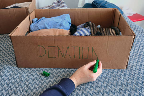 istock A man signs a cardboard donation box with a green marker. 2204309272