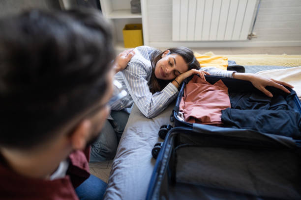 istock Young couple embracing while packing for travel 2204309712