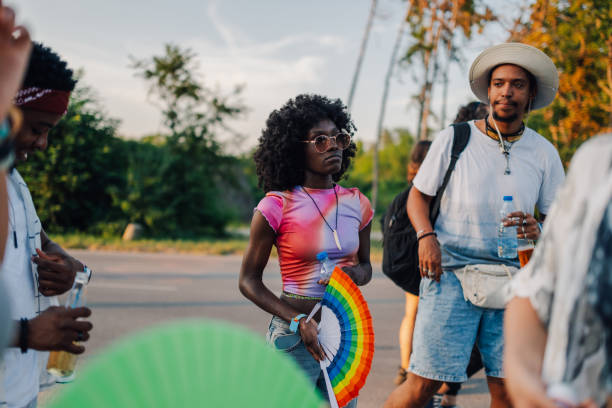 istock Young people holding rainbow fan at pride parade celebrating diversity 2204310861