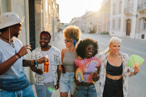 istock Young tourists walking down the street, drinking beer and having fun at sunset 2204310941