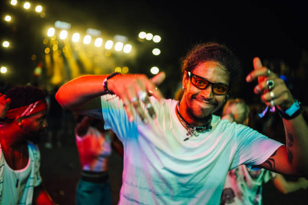 Lively scene at a night festival with a man dancing energetically under colorful lights. The vibrant atmosphere captures the essence of celebration and joyful nightlife