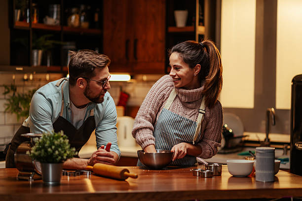 istock Smiling couple baking together in cozy kitchen 2204312817