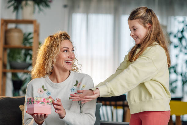 istock Daughter surprising her mother with a gift on mother's day 2204313427