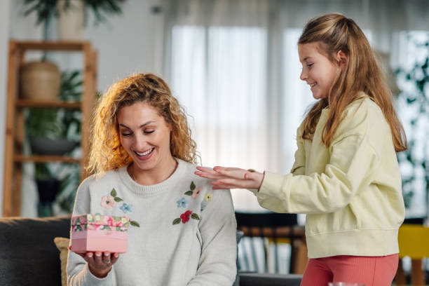 istock Daughter surprising her mother with a gift for mother's day 2204313459