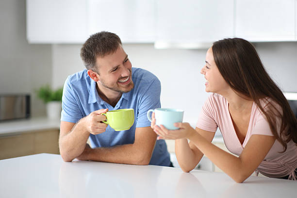 istock Happy couple drinking and talking in the kitchen 2204313941