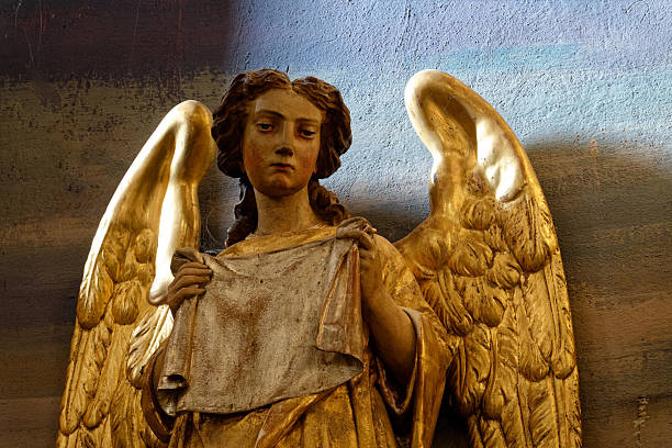 Weathered old angel statue in a cemetery – sepia toned image