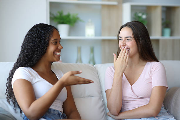 istock Woman covering mouth smiling in a conversation 2204314475