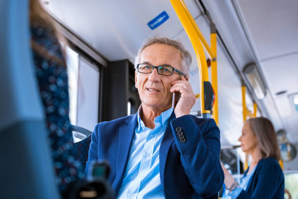 istock Senior businessman using phone commuting in bus 2204314538