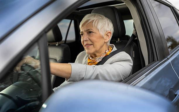 istock Senior woman driving car while enjoying pleasant day 2204314880