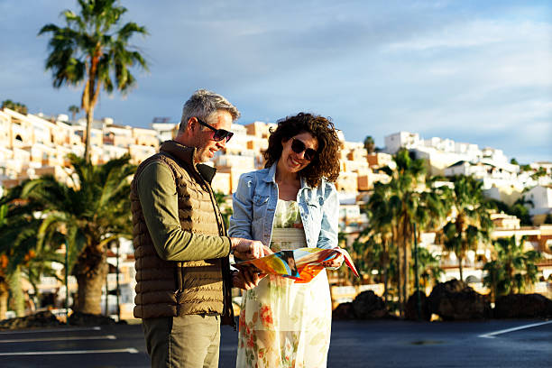 istock Happy travelers examining map while enjoying in a walk through the town. 2204317427