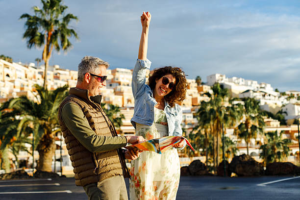 istock Happy travelers examining map while enjoying in a walk through the town. 2204317429