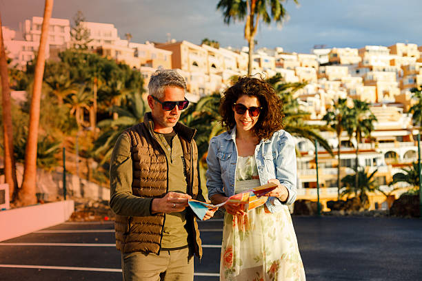 istock Happy travelers examining map while enjoying in a walk through the town. 2204317447