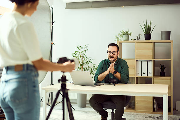 istock Professional Man Speaking in Front of Camera During an Office Video Shoot 2204319688