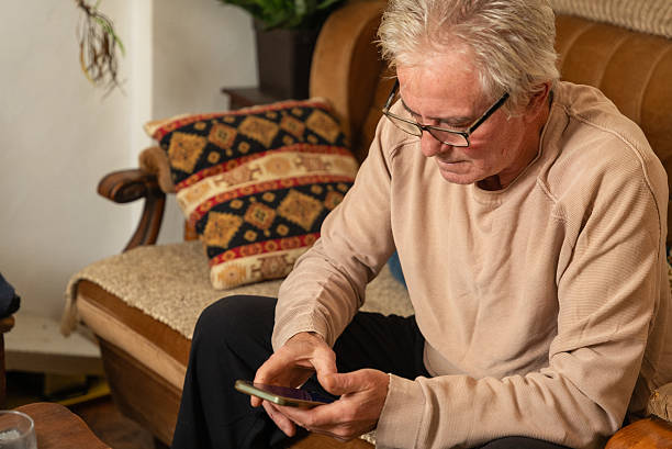 istock Senior man using smartphone at home: relaxing on sofa and browsing internet 2204322203