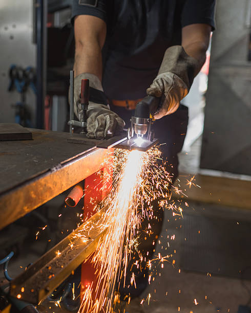 istock Worker operating an angle grinder, cutting metal and producing bright sparks 2204325790