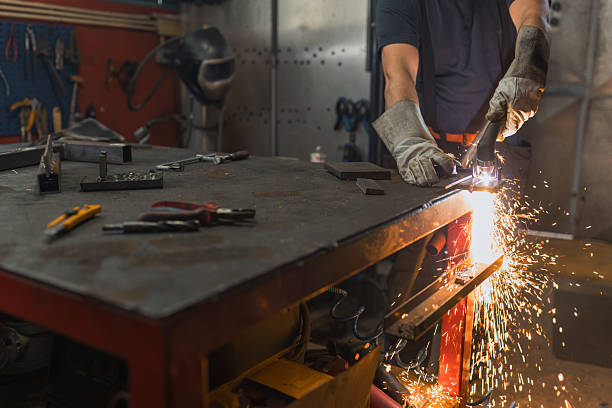 istock Worker using the grinder, producing, and repair in a home metalworking workshop 2204325798