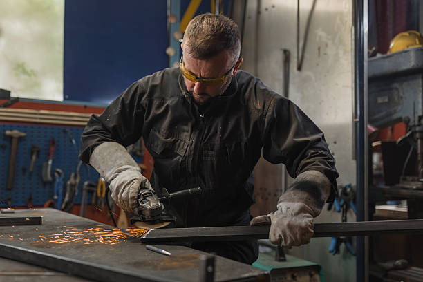 istock Manual worker wearing protective equipment grinding steel in a welding workshop 2204326635