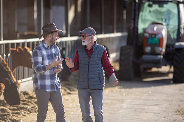 istock Two farmers talking on cow farm 2204327363