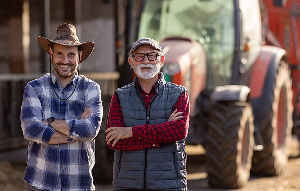 istock Two farmers in front of tractor on cattle farm 2204329435