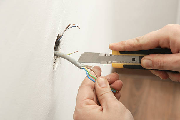 istock Electrical Outlet Repairing and Assembling - home improvement concepts. Master electrician installs a socket in the house. DIY home project. 2204329446