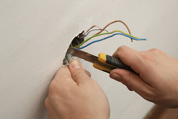 istock Electrical Outlet Repairing and Assembling - home improvement concepts. Master electrician installs a socket in the house. DIY home project. 2204329609