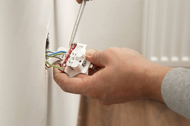 istock Electrical Outlet Repairing and Assembling - home improvement concepts. Master electrician installs a socket in the house. DIY home project. 2204330347