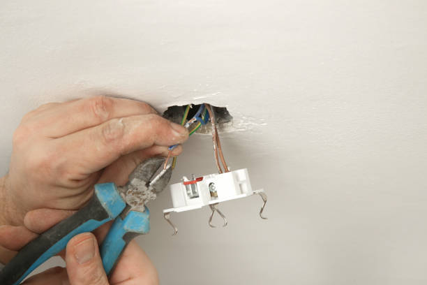 istock Electrical Outlet Repairing and Assembling - home improvement concepts. Master electrician installs a socket in the house. DIY home project. 2204330374