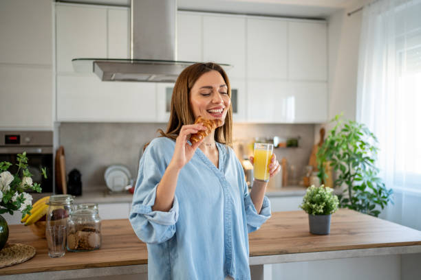 istock Happy woman enjoying breakfast in modern kitchen 2204332148