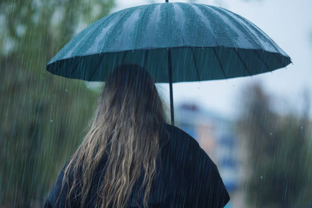 istock Woman with umbrella. Heavy rain 2204332179