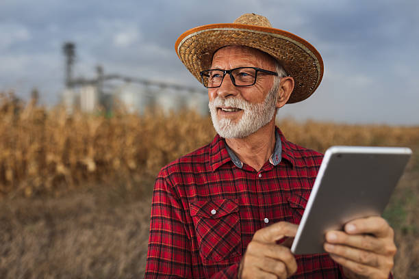istock Farmer with tablet in front of grain silos 2204335570
