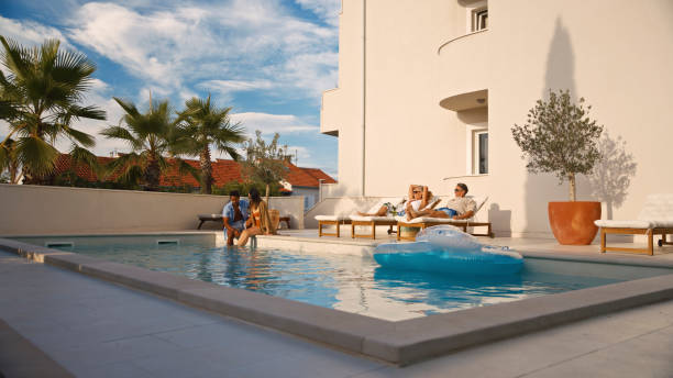 istock Diverse Friends Enjoying Poolside Relaxation At Modern Mediterranean Villa With Palm Trees 2204336967