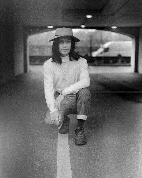 Young artist crouching in tunnel wearing hat and sweater
