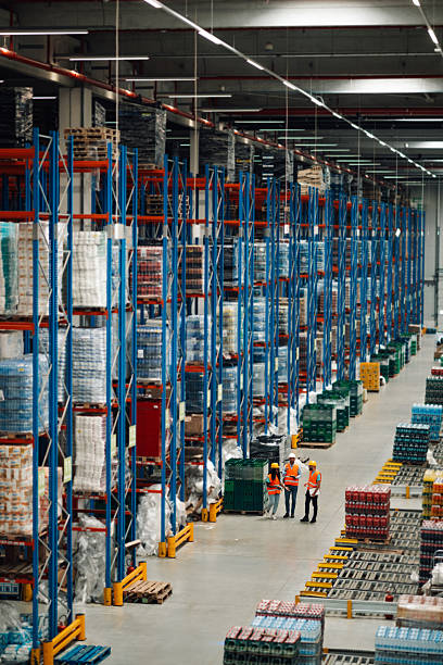 istock Warehouse workers checking inventory and discussing logistics in large distribution center 2204342156