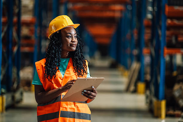 istock Female warehouse worker checking inventory using clipboard in logistics center 2204342183