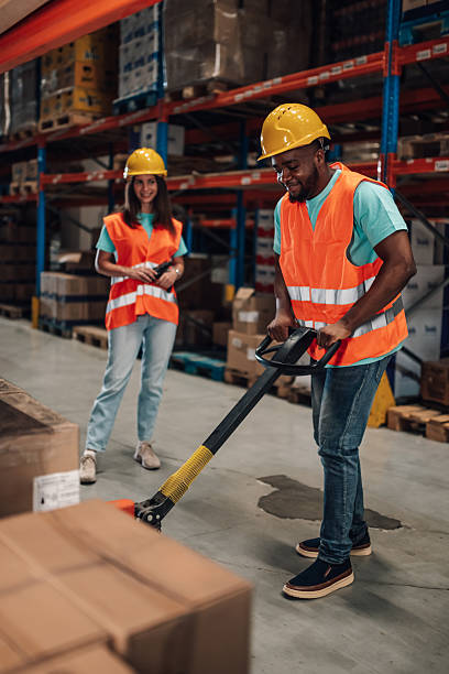istock Warehouse workers managing inventory with hand pallet truck and scanner 2204342405